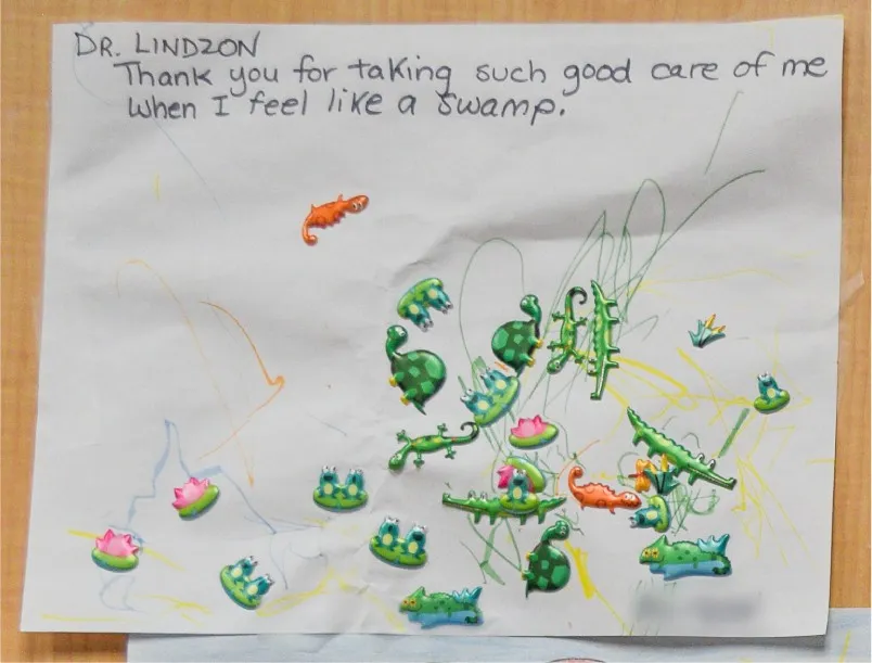 A child’s drawing that reads “Dr. Lindzon, thank you for taking such good care of me when I feel like a swamp” with frog and lizard stickers