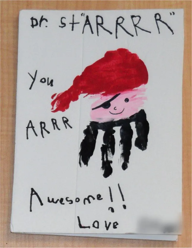 A child’s card that reads “Dr. Starrrr, you are awesome!!” with a handprint painted as a pirate